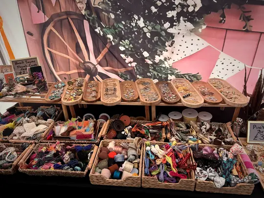 Baskets of ribbons, cords, lace and trays of pins and charms