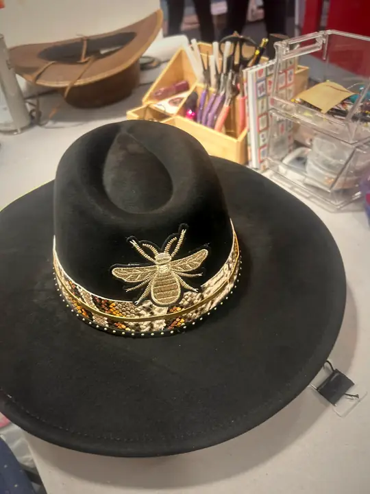 Black hat with gold band and bee brooch