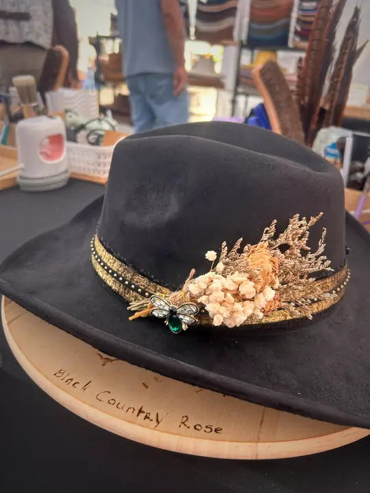 Black hat with gold band and dried flower spray