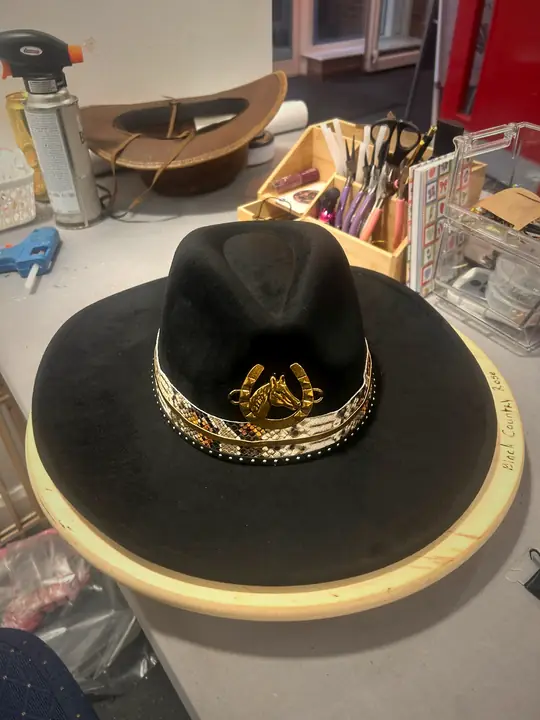 Black hat with gold band and horseshoe charm