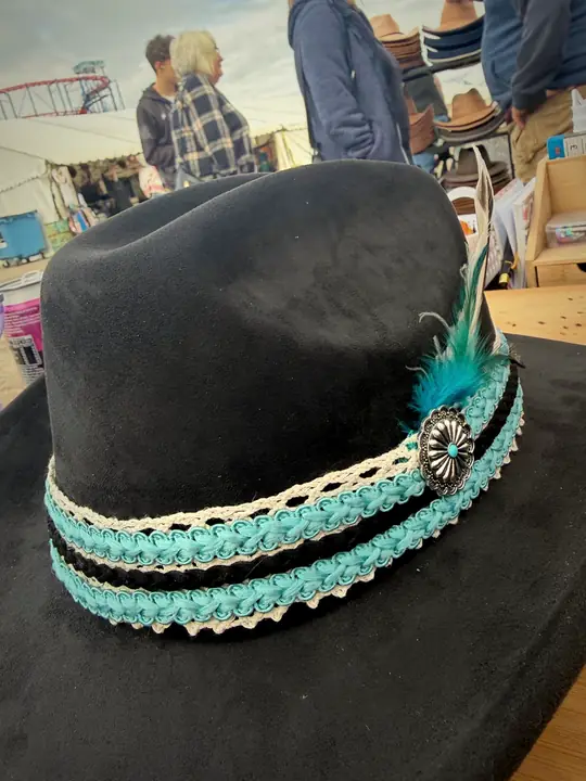 Black hat with turquoise lace band, concho and feather