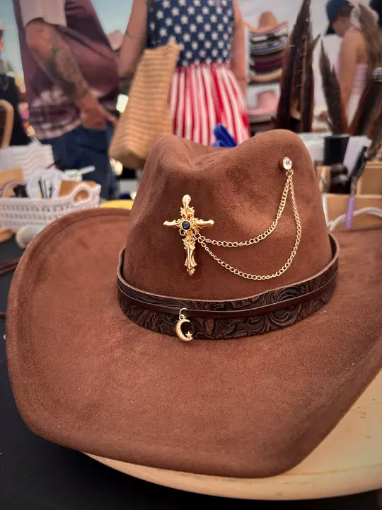 Brown hat with leather band, cross and chain charms