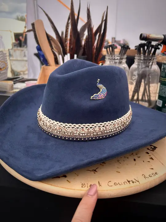 Navy hat with lace and crystal band and a peacock pin