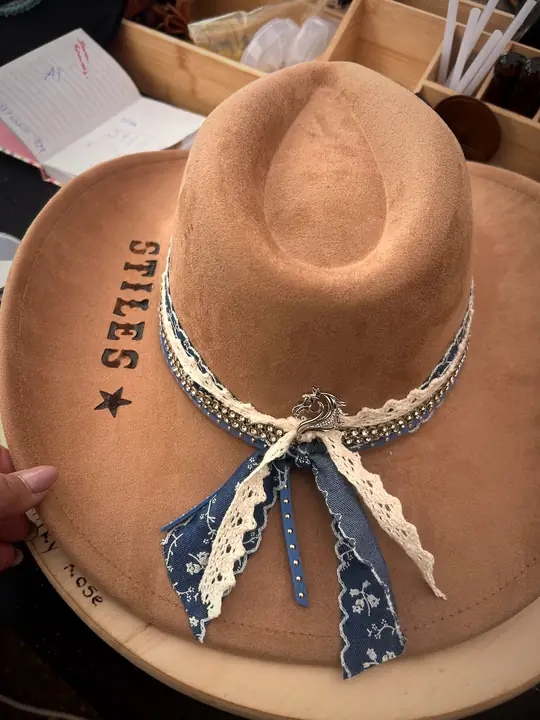 Tan hat with a name and star branded into the brim